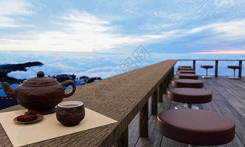 陶瓷茶具和干茶叶放在木头阳台或露台的木桌和椅子上有雾和阳光的早晨海的山上的热茶气氛背景图片