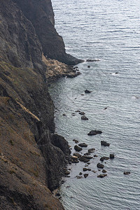 有岩石的悬崖和灰色的大海可怕的垂直海背景灰色的秋天风景危险的概念倒塌图片