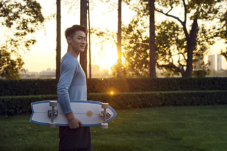 夕阳下的滑板男青年图片