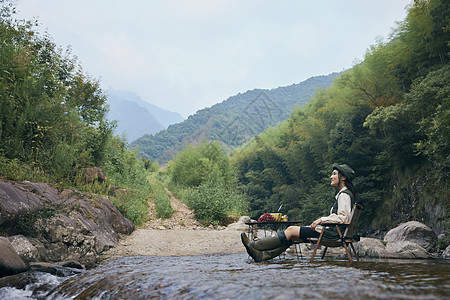 游玩山林年轻女青年享受溪边旅行背景