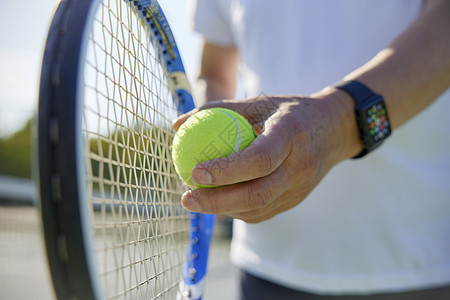 运动男性打网球老年男性打网球特写背景