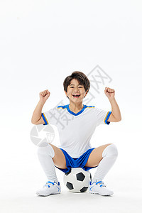 坐在足球上的小男孩图片