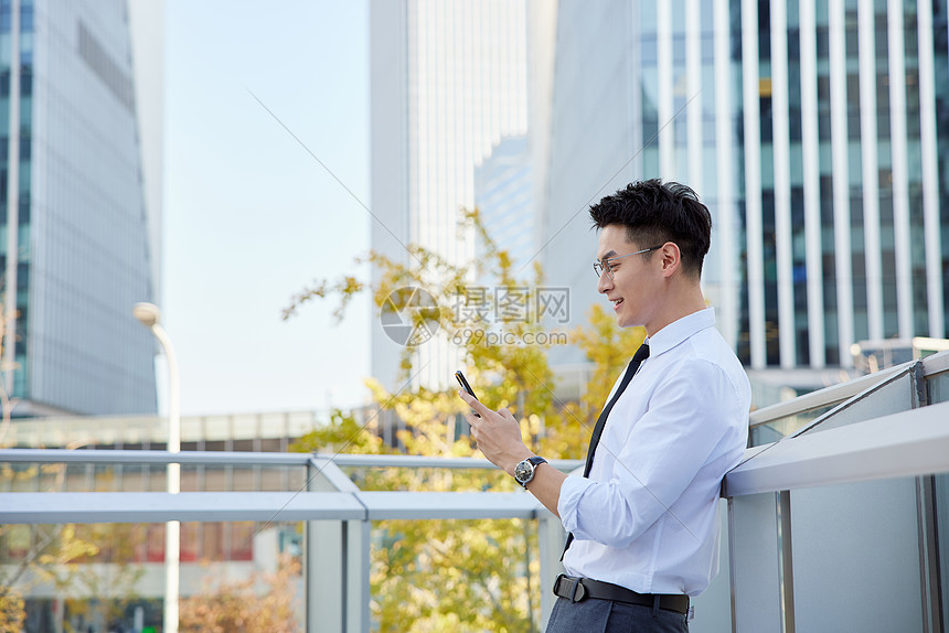 商务男士户外玩手机形象图片