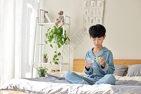 居家生病吃药的小男孩图片