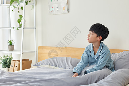 坐在床上孤单的小男孩图片素材