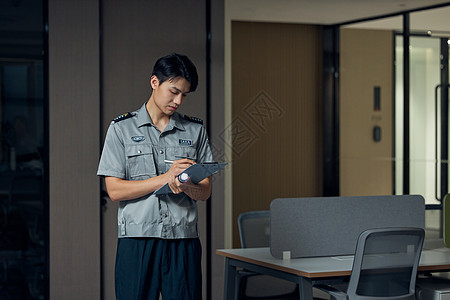 夜晚在商务楼工作巡逻的保安形象高清图片