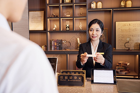 女性名片酒店前台女服务员递上房卡背景