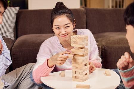 儿童玩具叠叠乐聚会玩叠叠乐桌游的年轻人背景