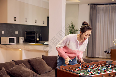 年轻女性玩桌式足球图片
