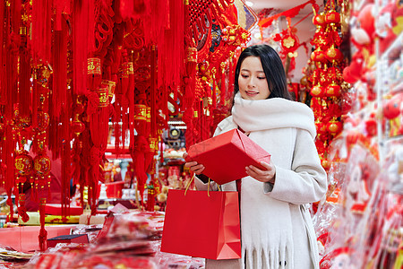 买年货的女子手拿新年礼物盒背景图片