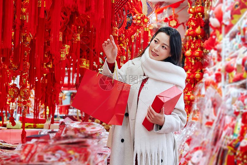 逛年货的青年女子手拿新年礼物盒图片