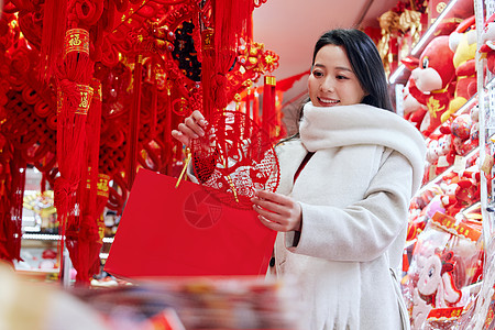 福窗花年货店里挑选窗花的女子背景