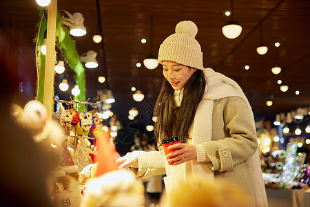 圣诞节背景冬日女性手捧咖啡逛圣诞集市背景