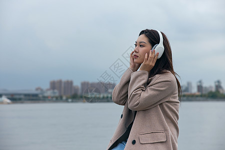 文艺美女在江边带着耳机伤感情绪的年轻女性背景