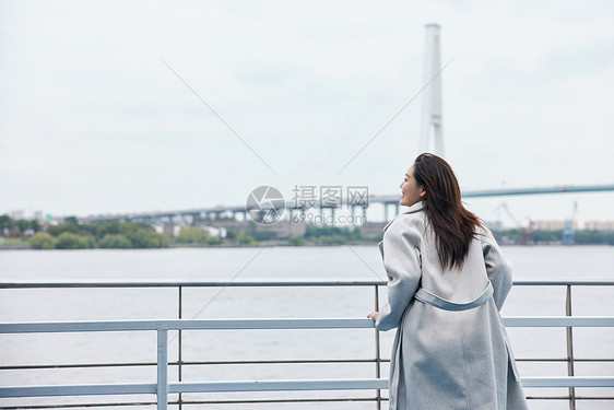 年轻美女站在江边背影图片