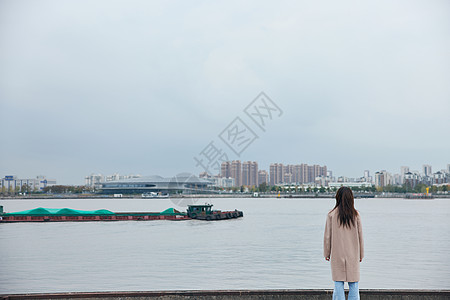 年轻美女站在江边背影图片