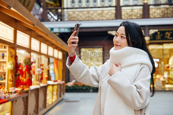 青年女子庙会里闲逛玩耍自拍图片