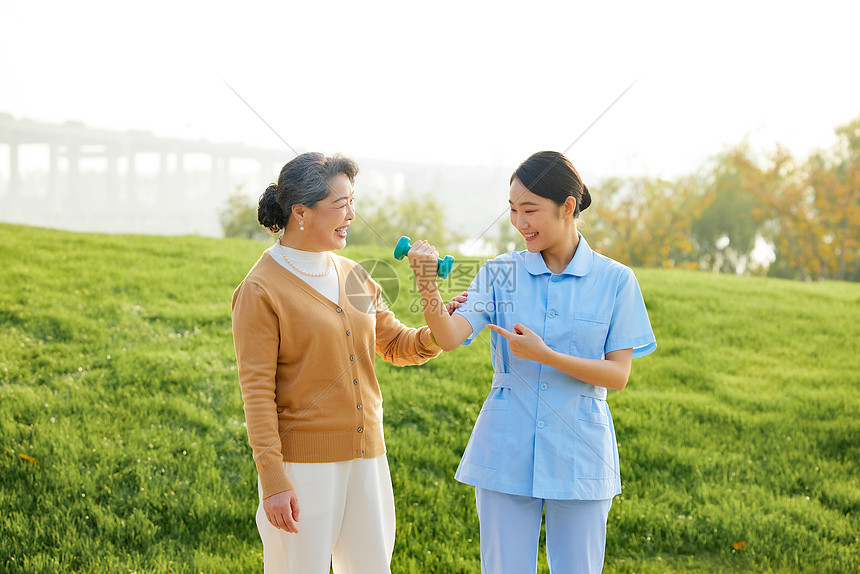 年轻女护工指导老人康复图片