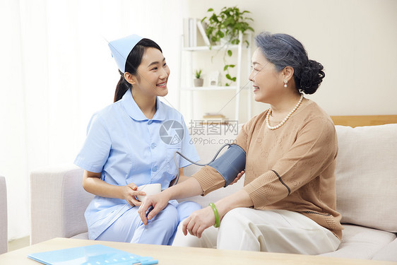 护工帮老年患者测量血压图片
