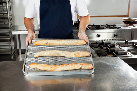 男厨师在工业厨房中做面包图片