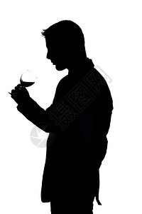 一位年轻男子拿着红酒杯在白色工作室背景上图片