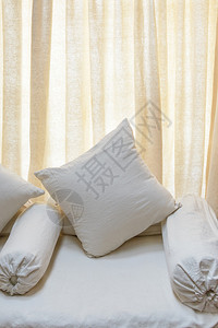 白色沙发和靠垫背光窗帘背景图片