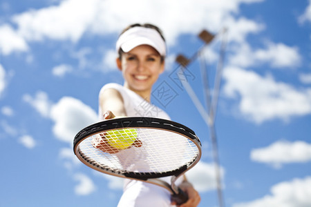 Brunette网球运动员站在网球场上图片