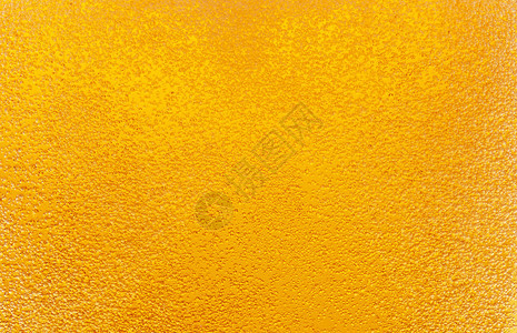 啤酒中金色气泡的特写镜头背景图片