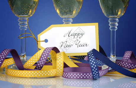 以三杯香槟杯子派对彩带和装饰品来关闭新年快背景图片