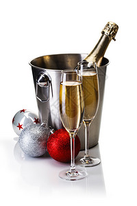 香槟瓶装在桶里杯着香槟和圣诞节球的杯子图片
