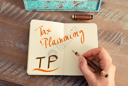 复古效果和女人手在笔记本上用钢笔写便条的色调图像手写文本TP税务规划图片