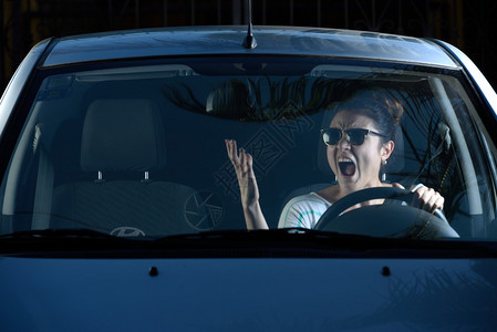 愤怒的女人在开车时对图片