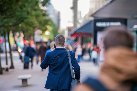 穿着短裤的经理拿着智能电话打个电话在伦敦街上图片