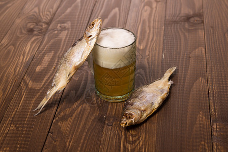 啤酒起泡木桌上的鱼干图片