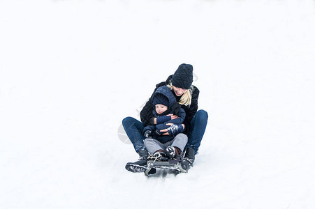 妈带着小男孩骑狗拉雪橇图片