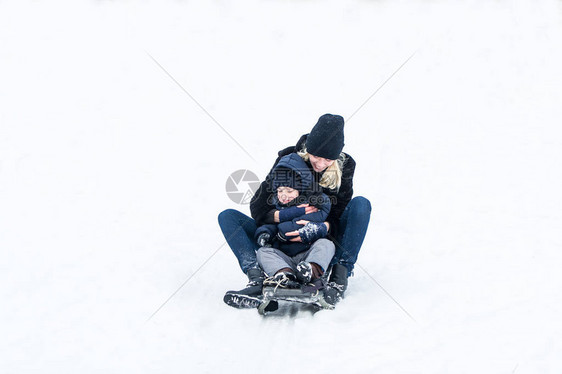 妈带着小男孩骑狗拉雪橇图片