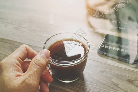 手握咖啡杯或茶叶和烟头木制桌上智能电话过滤器效背景图片