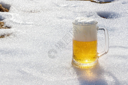 在春天融雪的背景下喝啤酒图片