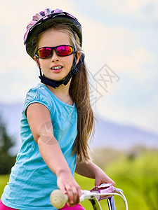 女孩在路上骑脚踏车去绿色草地上跑图片