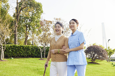 老人陪伴年轻女护工陪伴老人公园散步背景