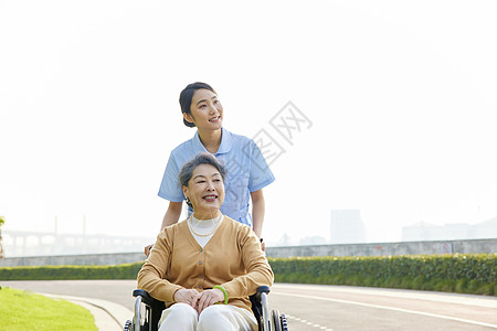 老年女人女护工照顾行动不便的老人背景