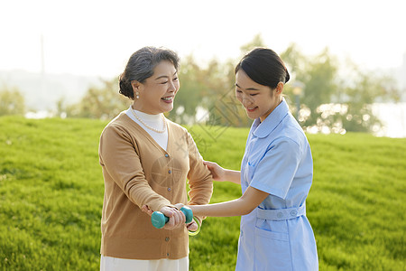 户外年轻女护工指导老人康复图片