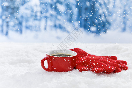 雪地上的红色马克杯和手套背景图片