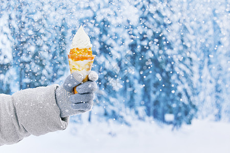 雪地里手拿冰淇淋特写图片