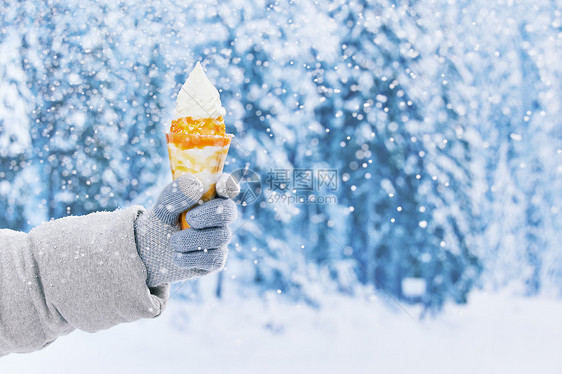 雪地里手拿冰淇淋特写图片