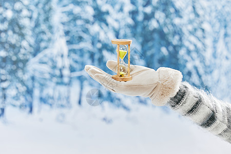 雪地里手捧沙漏手部细节图片