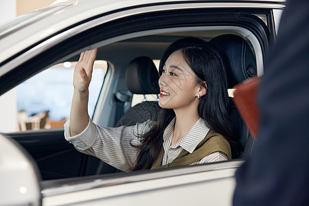 女性在汽车4s店试驾新能源汽车背景图片