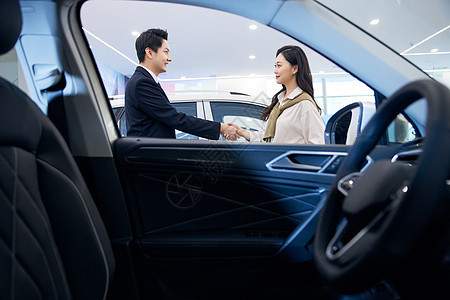 女顾客与汽车销售握手成交图片