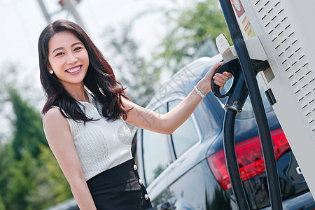 从充电桩取充电的漂亮青年女人图片