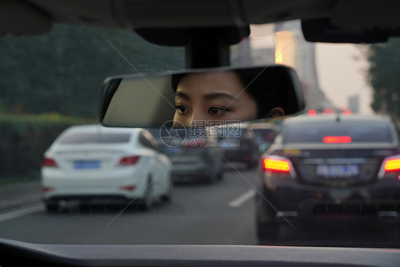 后视镜里驾车的青年女人图片